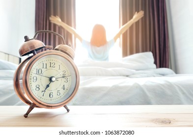 Morning of a new day, alarm clock wake up man sitting in the room. Women stretch the muscles at window. Health and care concepts - Shutterstock ID 1063872080