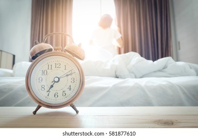 
Morning of a new day, alarm clock wake up woman in the room. A woman stand at window. Health concept. - Shutterstock ID 581877610