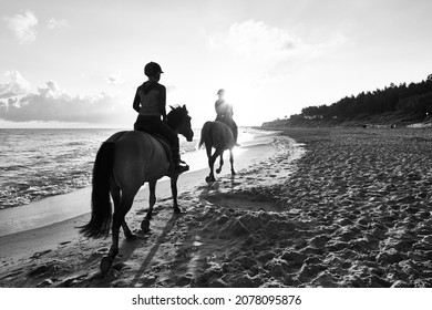 Morning on the Baltic Sea beach and horse riders enjoying the beautiful morning