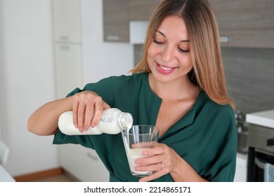 Morning Portrait Of Young Smiling Woman Fills The Glass With Kefir. Beautiful Girl Drinking Milk.