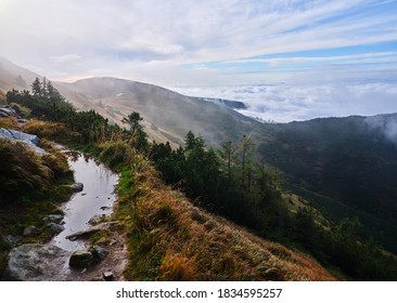 Morning reflection in i puddle on a mountain ridge walking path in a slope above the clouds, Low Tatras, Nizke Tatry, Slovakia. - Shutterstock ID 1834595257
