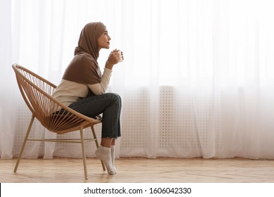 Morning Relax. Young Muslim Woman In Hijab Sitting In Wicker Chair, Drinking Coffee Or Tea Against Window At Home, Free Space - Powered by Shutterstock