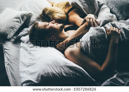 Similar – Young couple in love embracing lying over a bed