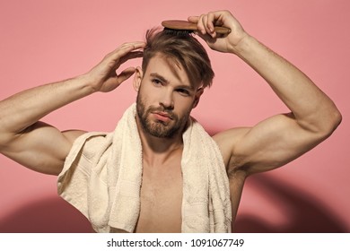 Morning Routine Concept. Macho With Bath Towel On Sexy Chest. Beauty, Grooming, Hygiene. Haircare, Wellness, Health. Man Brush Hair With Hairbrush On Pink Background.