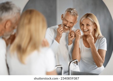 Morning Routine. Smiling Mature Couple Using Dental Floss In Bathroom Together, Happy Senior Spouses Cleaning Teeth And Laughing, Making Dental Hygiene Near Mirror At Home, Selective Focus - Powered by Shutterstock