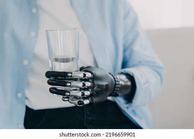 Morning Routines Of Person. Girl Is Using Futuristic Robotic Arm Prosthesis And Holding Glass Of Water At Home. Modern Bionic Prosthesis. Healthy Lifestyle After Amputation Surgery.