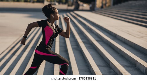 Morning Running. African American Girl In Sports Uniform With Wireless Headphones And Fitness Tracker Runs Up The City Stairs, Panorama, Free Space