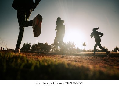 Morning Running Training In Kenya. A Group Of Endurance Runners Run On Red Soil At Sunrise. Morning Running Motivation For Training.