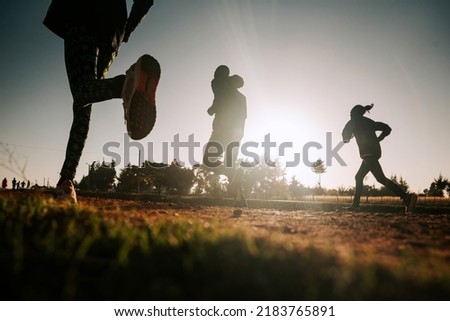 Morning running training in Kenya. A group of endurance runners run on red soil at sunrise. Morning running motivation for training.