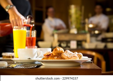 Morning scene of pouring fresh juices at hotel breakfast table