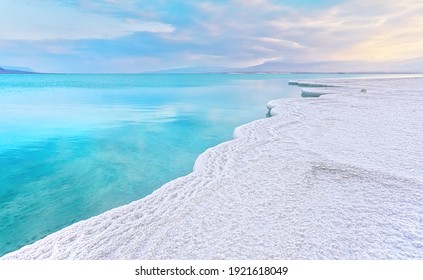 Morning scenery - white salt crystals beach, clear water near, typical landscape at Dead Sea shore, Israel
