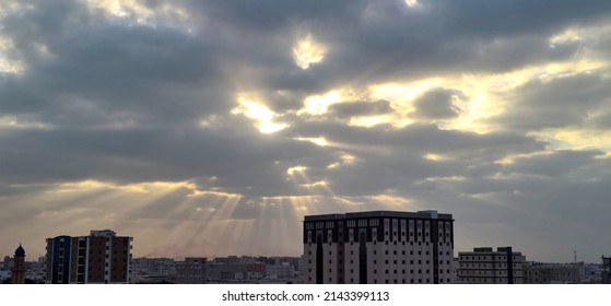 Morning Sky With The Sun Shining Through The Clouds Over Buildings 