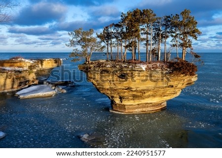 Morning sun lights up a rock formation on Lake Huron. Locally known as Turnip Rock, it is a popular destination for kayakers during the summer season. As winter heralds a new beginning, pancake ice be