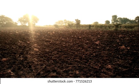 Morning Sun Rays Over Farm Soil In India As Beautiful Background