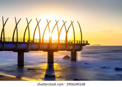Morning sun rays shine through the unique design of the whalebone pier, located in Umhlanga Rocks, South Africa  - Shutterstock ID 1906240168