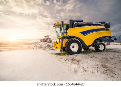 Morning Sunrise Shot Of Yellow Combine Harvester Prepared For New Season During Cold Winter Morning.