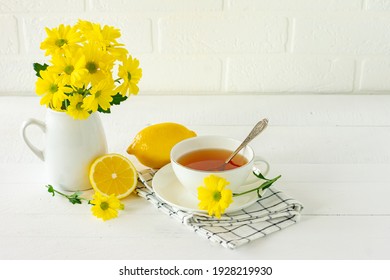 Morning tea with lemon and yellow chrisantemum flowers.