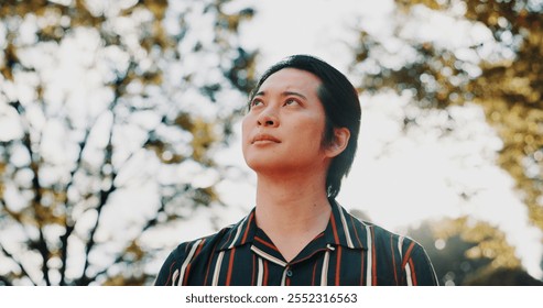 Morning, thinking and Asian man in park for wellness, ideas and relax with reflection, nostalgia and inspiration. Walking, nature and person outdoors for fresh air, peaceful mindset and calm in Japan - Powered by Shutterstock