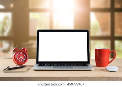 Morning time with warm light. Blank laptop screens on working desk with a  pen, document, text book, alarm clock, laptop, and coffee red cup. business concept. - Powered by Shutterstock