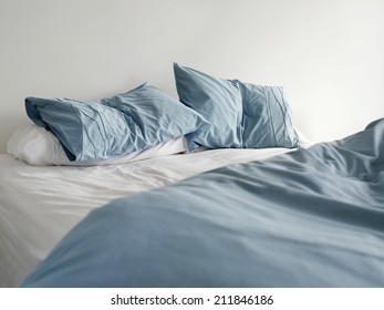 Morning View Of An Unmade Bed With Crumpled Blue Bed Linens And No People