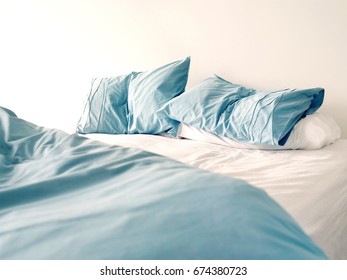 Morning View Of An Unmade Bed With Crumpled Blue Bed Linens And No People