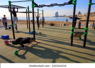 Morning Workout At The Outdoor Gym On Barceloneta Beach. Barcelona, Catalonia, Spain / Feb 08.2019. Sunny Day, Long Shadows And Clear Blue Sky. 