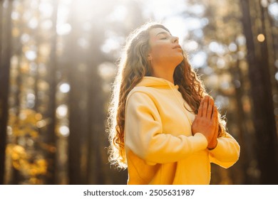 Morning yoga and meditation in peaceful natural forest. Pretty woman doing yoga exercises. Heather lifestyle.