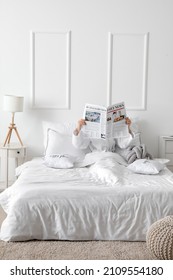 Morning Of Young Woman Reading Newspaper In Bed