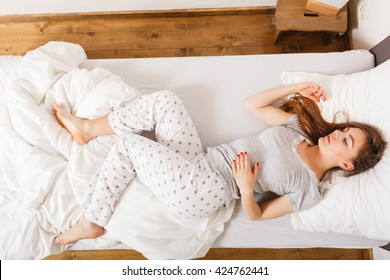 Mornings People Concept. Sleepy Woman Sleeping In The Bed. Attractive Lady Changing Sleep Positions.