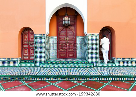 Moroccan architecture exterior detail of painted doors and mosaic tile work. Design symmetry. Location: Marrakech