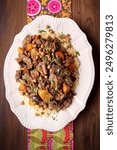 Moroccan Family Dinner Platter of, Beef Stew with Couscous and Vegetables on a Wooden Table