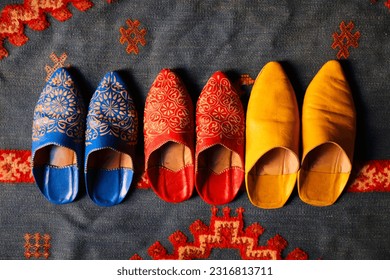 Moroccan handicraft. Traditional babouche leather footwear on ornamental Moroccan wool rug.