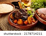 Moroccan lamb and Vegetables Tangine with bread served in a dish isolated on wooden background side view