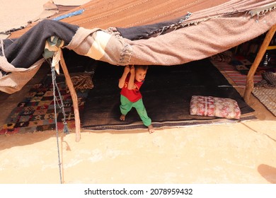 Moroccan Local Cute Child Boy Lives With Nomadic Bedouin Family At Sandy Dune In Traditional Tent Camp Like Native Berber Tribe In African Hot Sahara Desert At Merzouga, Morocco, Africa. May 17, 2018.