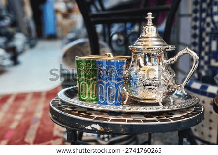 Moroccan mint tea set with silver teapot and colorful glasses on tray