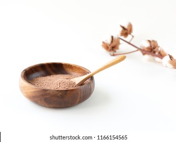 Moroccan Red Clay Powder In The Woogen Plate. Cotton Branch On The Background. Home Skincare And Spa. Minimalistic Composition. Easy Detox. Side View, Copy Space.