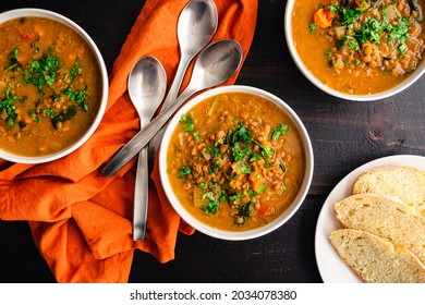 Moroccan Sweet Potato Lentil Soup Garnished with Fresh Herbs: Vegetable and lentil soup with fresh herbs served with fresh bread