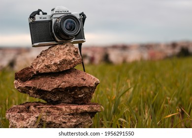 Morocco, Casablanca - January 30, 2021 : An Old Film Camera PENTAX K1000 Is Displayed Inside A Green Grass In Nature.