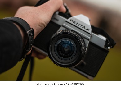 Morocco, Casablanca - January 30, 2021 : Photographer's Hand Holding An Old Film Camera PENTAX K1000 In Nature.