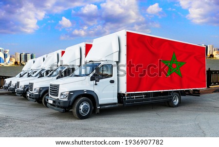 Morocco flag on the back of Five new white trucks against the backdrop of the river and the city. Truck, transport, freight transport. Freight and Logistics Concept