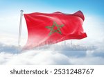 Morocco flag wavering in beautiful clouds with building skyline. The flag with drone shot in beautiful sky. Morocco national flag for independence day.