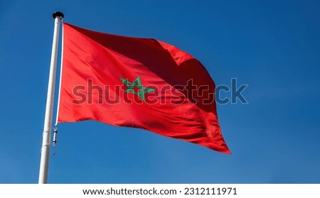 Morocco sign symbol. Moroccan national official flag on flagpole waving in the wind, blue sky background