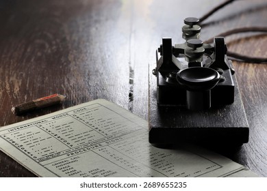morse key with morse code chart on desk