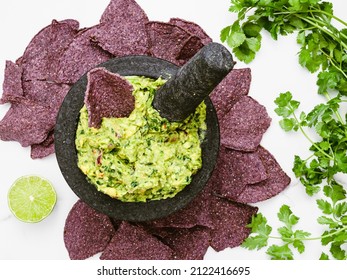 Mortar And Pestle With Guacamole And Blue Corn Chips.