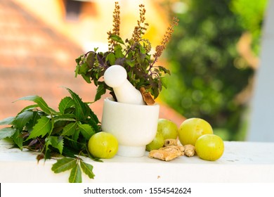 Mortar And Pestle With Neem Leaves, Tulsi Leaves, Indian  Amla (Gooseberry), Dry Ginger Etc. Trivandrum, Kerala, India.