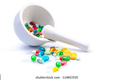 Mortar and pestle with pills against a white background