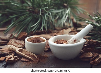 Mortars Of Powdered Pine Bark, Dry Pine Bark On Wooden Board. Branches Of Pine Tree On Background.