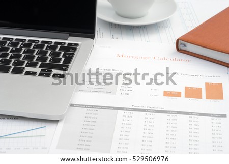 Mortgage calculator reports, laptop and coffee