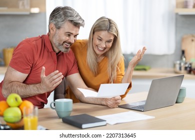 Mortgage Concept. Emotional Spouses Middle Aged Handsome Man And Pretty Blonde Woman Reading Letter From Bank, Using Laptop And Drinking Coffee, Celebrating Success, Kitchen Interior, Copy Space