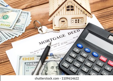 Mortgage Deed With Calculator, Money, Model Of House And Key On The Wooden Background. Real Estate Concept.